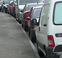 Cars park close to each other and the kerb in Britain